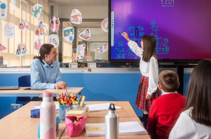 student writes on a board in classroom | image accompanies blog post on the power of strong school branding for awareness and recognition | truth tree school marketing blog post