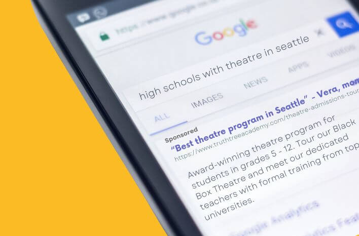 A smartphone displaying a Google search for “high schools with theatre in Seattle,” showing search results for local theatre programs. | Accompanies a blog post by Truth Tree | Truth Tree is a team of school marketing experts partnering with private and independent schools
