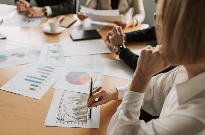 Group of professionals reviewing charts and marketing data around a conference table, representing analysis of private school search trends.